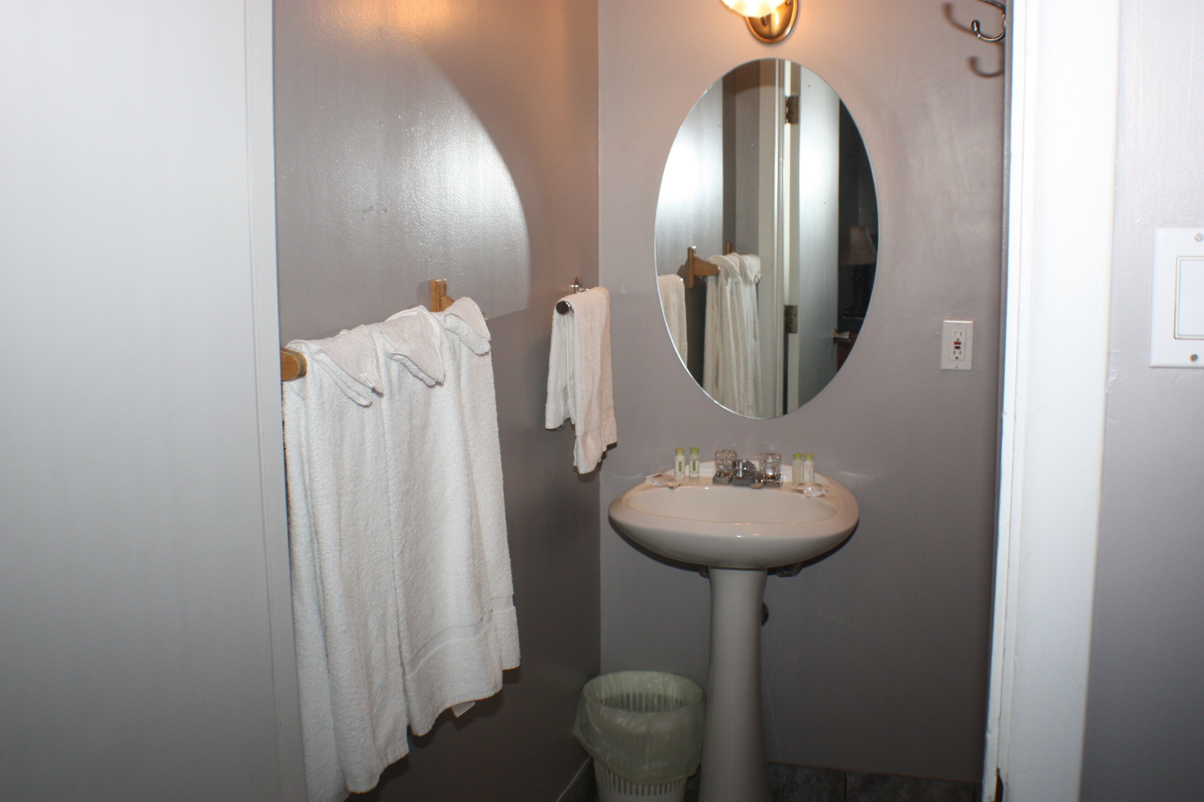 A bathroom with a sink, mirror, and two towels hanging on a rack.