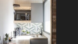 Una cocina compacta con microondas integrado, un lavabo y lavavajillas.