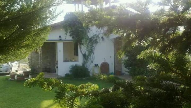 A white building with a garden in front, surrounded by trees. - Villa Eva Agios Nikolaos (Sithonia)