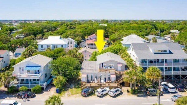 A residential area with houses, a yellow arrow pointing to a specific house, and a parking lot with cars. - Salty Shack #B - Across from the Beach - Central Location (Folly Beach)