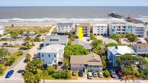 A coastal town with beachfront properties, including multi-story buildings and single-family homes with parking spaces. - Salty Shack #B - Across from the Beach - Central Location (Folly Beach)