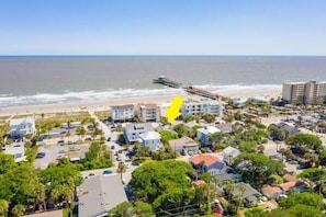 A coastal residential area with houses, a pier, and a beach.