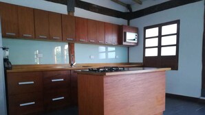 Una cocina con armarios de madera, microondas integrado y una isla central.