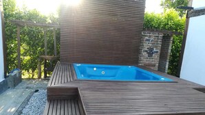 Una terraza de madera con un jacuzzi.