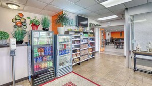 A clean, well-lit indoor space with vending machines, shelves stocked with snacks, and a seating area in the background. - Econo Lodge Neenah (Neenah)