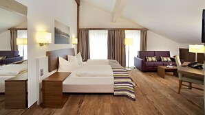 A hotel room with a bed, a sofa, a desk, and a TV. - Hotel Greinwald (Marktoberdorf)