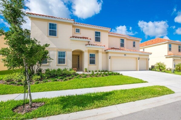 A two-story residential building with a beige facade, red-tiled roof, and a well-maintained lawn. - H6112 Beautiful 14 Bedroom 11 Bathroom Resoret (Davenport)