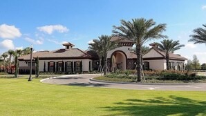 A large, two-story building with a curved driveway and palm trees. - H6108amazing Brand new 9 Bedroom 7 Bathroom Resort (Davenport)