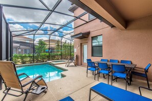 A pool area with lounge chairs and a table, surrounded by a glass enclosure. - H5424 Ultimate 5 Bedroom 5 Bathroom Luxury Villa (Davenport)
