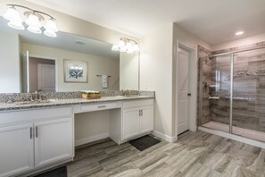 A bathroom with a granite countertop sink, a large mirror, and a glass shower enclosure. - H5424 Ultimate 5 Bedroom 5 Bathroom Luxury Villa (Davenport)