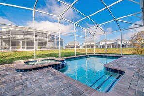 A swimming pool with a glass enclosure, surrounded by a brick patio. - H1675 Brand new Luxury 8 Bedroom 5 Bathroom Villa (Davenport)