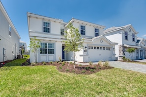 A two-story residential building with a white exterior, a garage, and a well-maintained lawn. - H1596 Brand new Amazing 6 Bedroom 6 Bathroom Fiji (Davenport)