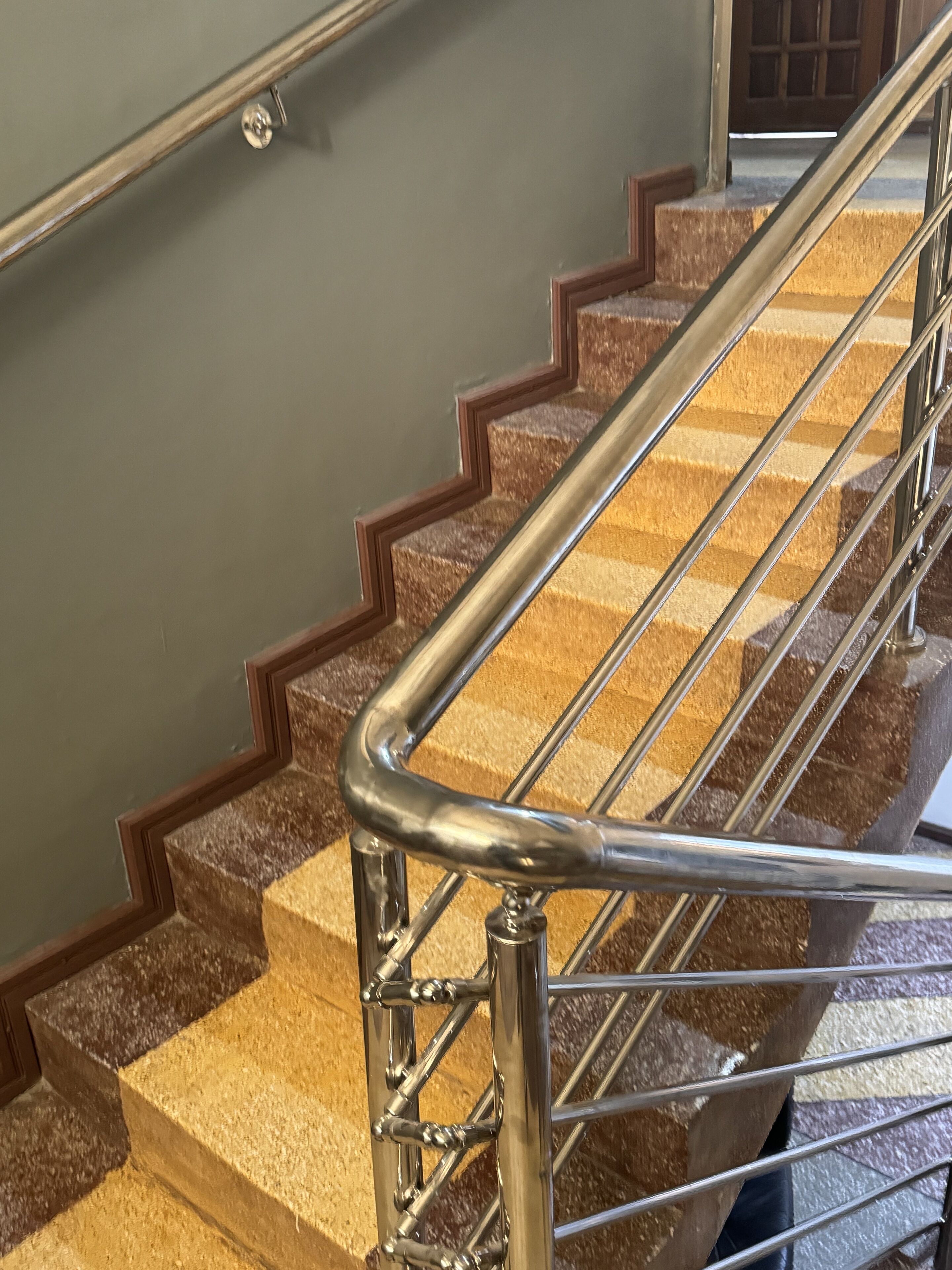 Un escalier avec une rampe métallique et des marches en bois.