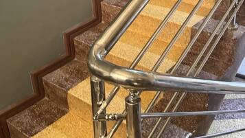Un escalier avec une rampe métallique et des marches en bois.
