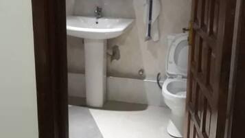 A small bathroom with a sink, mirror, and toilet.