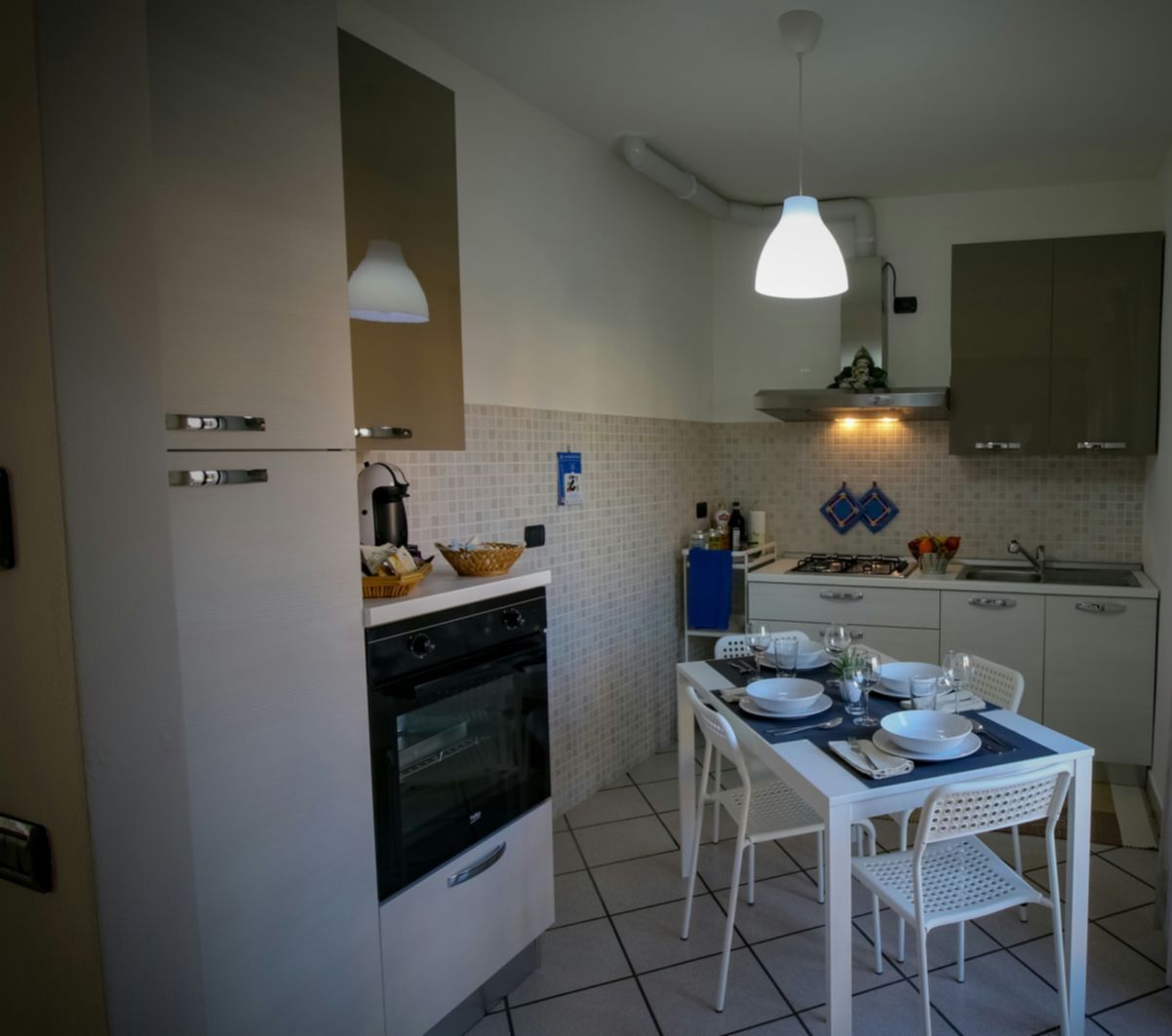 Una cocina compacta con estufa, horno y mesa de comedor para dos personas.