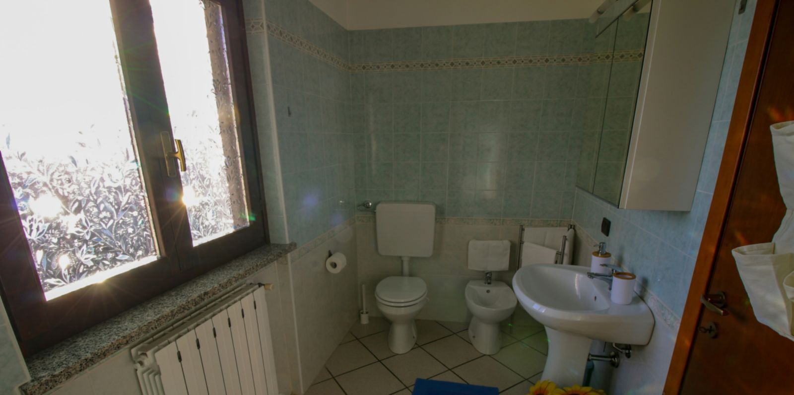 Une salle de bain équipée de toilettes, d’un bidet et d’un lavabo.