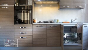 Une cuisine moderne avec des meubles en bois, un four à micro-ondes encastré, un four et un lave-vaisselle.
