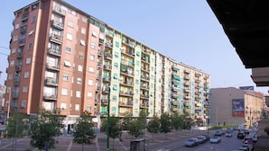 A multi-story residential building with balconies, a pedestrian walkway, and a street with cars. - B&B Citta Studi (Milan)