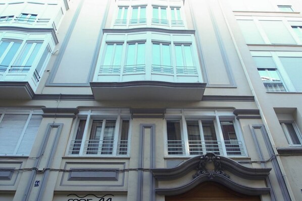 Un edificio a più piani con uno stile architettonico classico, caratterizzato da ampie finestre e modanature decorative.