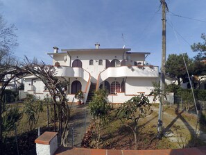 A multi-story building with a white facade, multiple balconies, and a central staircase. - Appennini Villas (Comacchio)