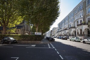 A street lined with parked cars and a sign for 'SLUKE'S'. - Chelsea Residential Atmosphere (London)