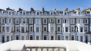 A row of terraced houses with white facades, multiple windows, and balconies. - Chelsea Residential Atmosphere (London)