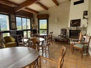 Comedor con muebles de madera, ventanas amplias y chimenea.