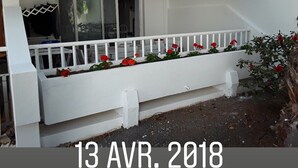 Un edificio blanco con balcón y ventana, y un sello de fecha que indica 13 de ABR. 2018.