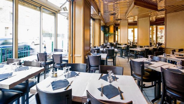 A restaurant with multiple tables and chairs, large windows, and a modern ceiling design. - Le Theatre (Suresnes)