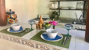 A kitchen with a gas stove, a sink, and a shelf with glassware. - Private Casita, 1BR, A/C, 1 Block to the Best Beach in Zihuatanejo (Zihuatanejo)