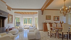 A spacious living room with a marble floor, a dining area with wooden chairs, and a chandelier. - Villa Cuculo - Holiday villa with swimming pool in Valdichiana, Tuscany (Patrignone)