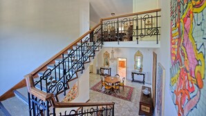 A multi-level interior with a staircase, a dining area, and a large abstract painting. - Villa Cuculo - Holiday villa with swimming pool in Valdichiana, Tuscany (Patrignone)