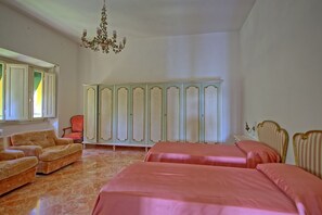 A bedroom with two beds, a wardrobe, a chair, and a chandelier. - Villa Cuculo - Holiday villa with swimming pool in Valdichiana, Tuscany (Patrignone)