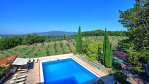 A rectangular swimming pool with a clear blue water, surrounded by a stone deck and a few lounge chairs. - Villa Cuculo - Holiday villa with swimming pool in Valdichiana, Tuscany (Patrignone)