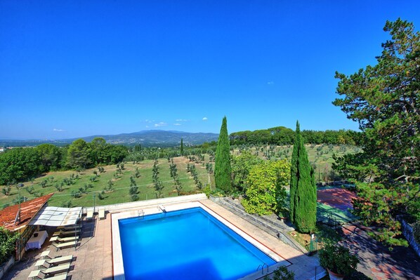 A rectangular swimming pool with a clear blue water, surrounded by a stone deck and a few lounge chairs. - Villa Cuculo - Holiday villa with swimming pool in Valdichiana, Tuscany (Patrignone)