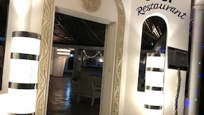 An entrance to a restaurant with a sign reading "CHUI Restaurant". There are decorative pillars and a patterned ceiling.