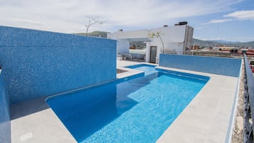 Alberca al aire libre y sombrillas en la alberca