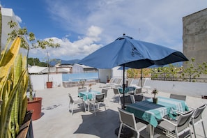 Relax in style on our outdoor patio, surrounded by lush greenery and shaded by a large umbrella.