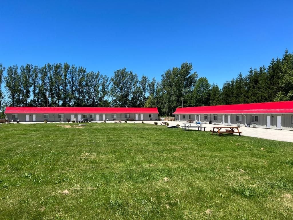 Una hilera de edificios con tejados rojos y un campo de césped delantero.