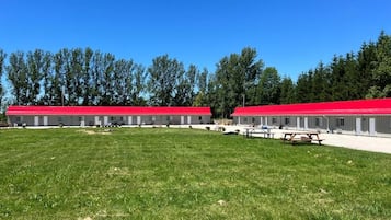 Una hilera de edificios con tejados rojos y un campo de césped delantero.