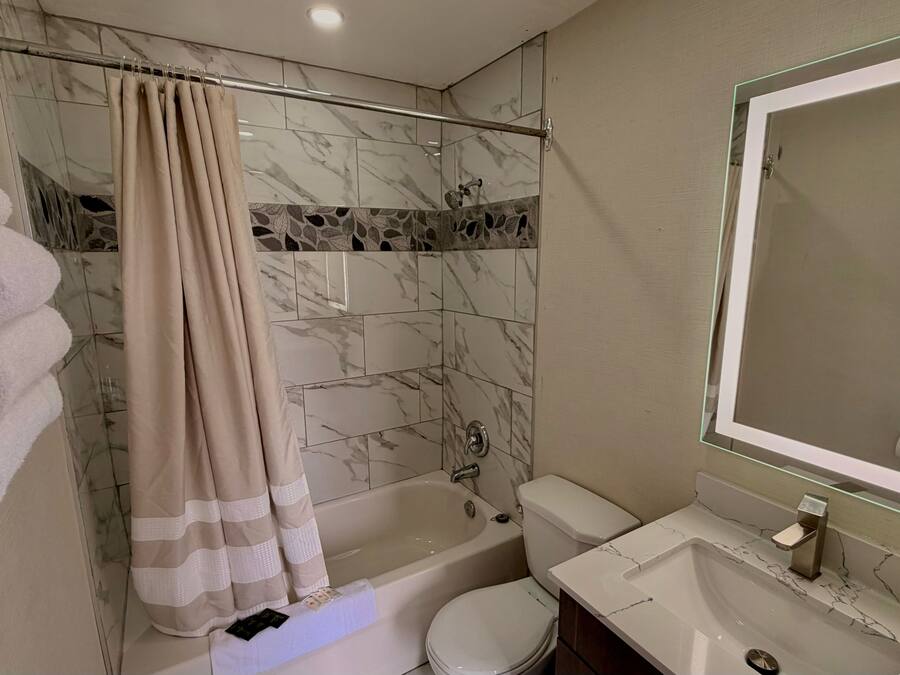 Un baño con bañera, inodoro y lavamanos.