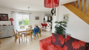 A dining area with a table and chairs, a red sofa, and a staircase.