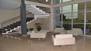 A modern interior with a staircase, seating area, and large windows.