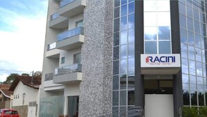 A multi-story building with a sign for RACIN SUITES.