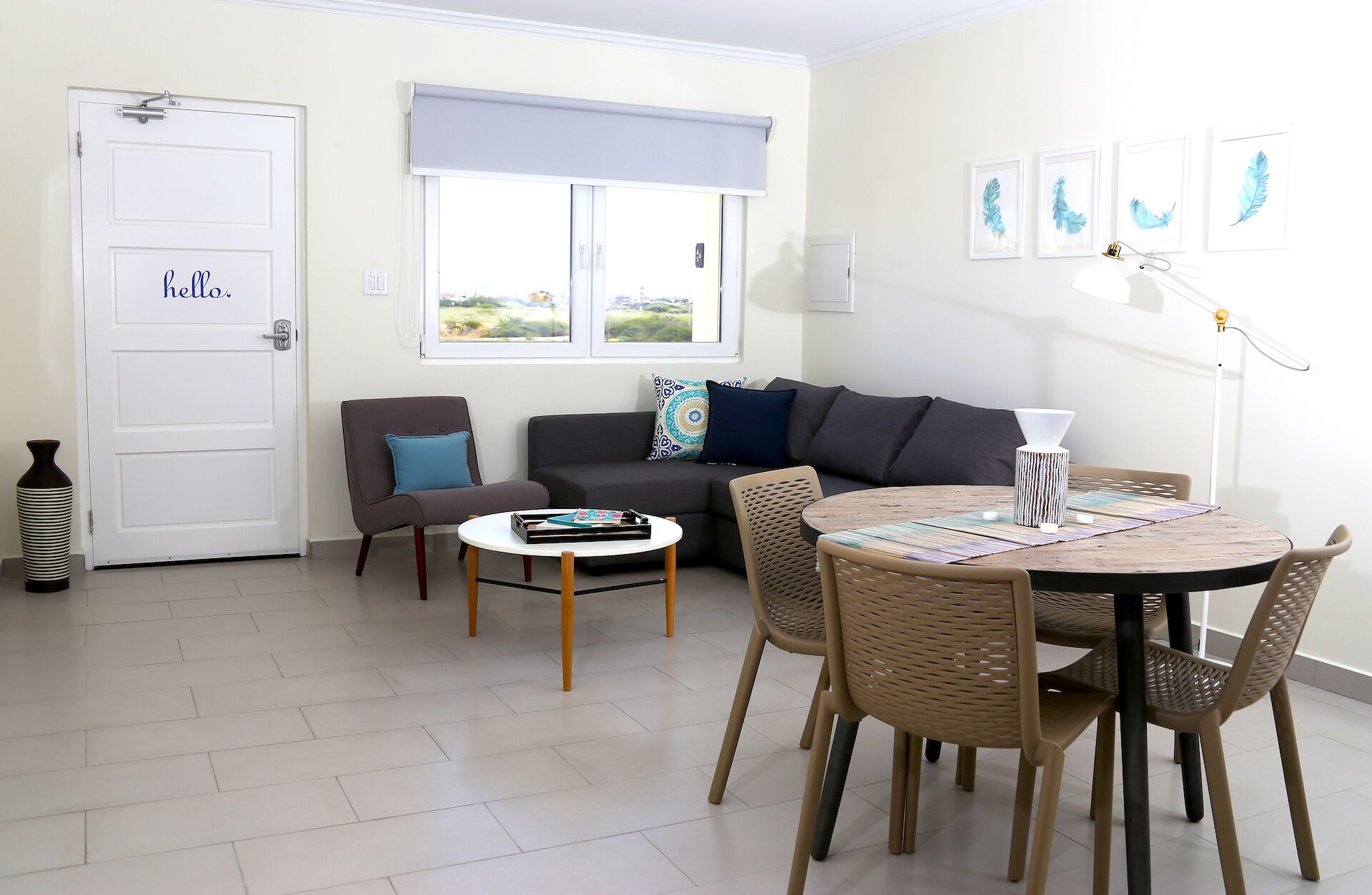 A living room with a sofa, a coffee table, and a dining area with chairs.