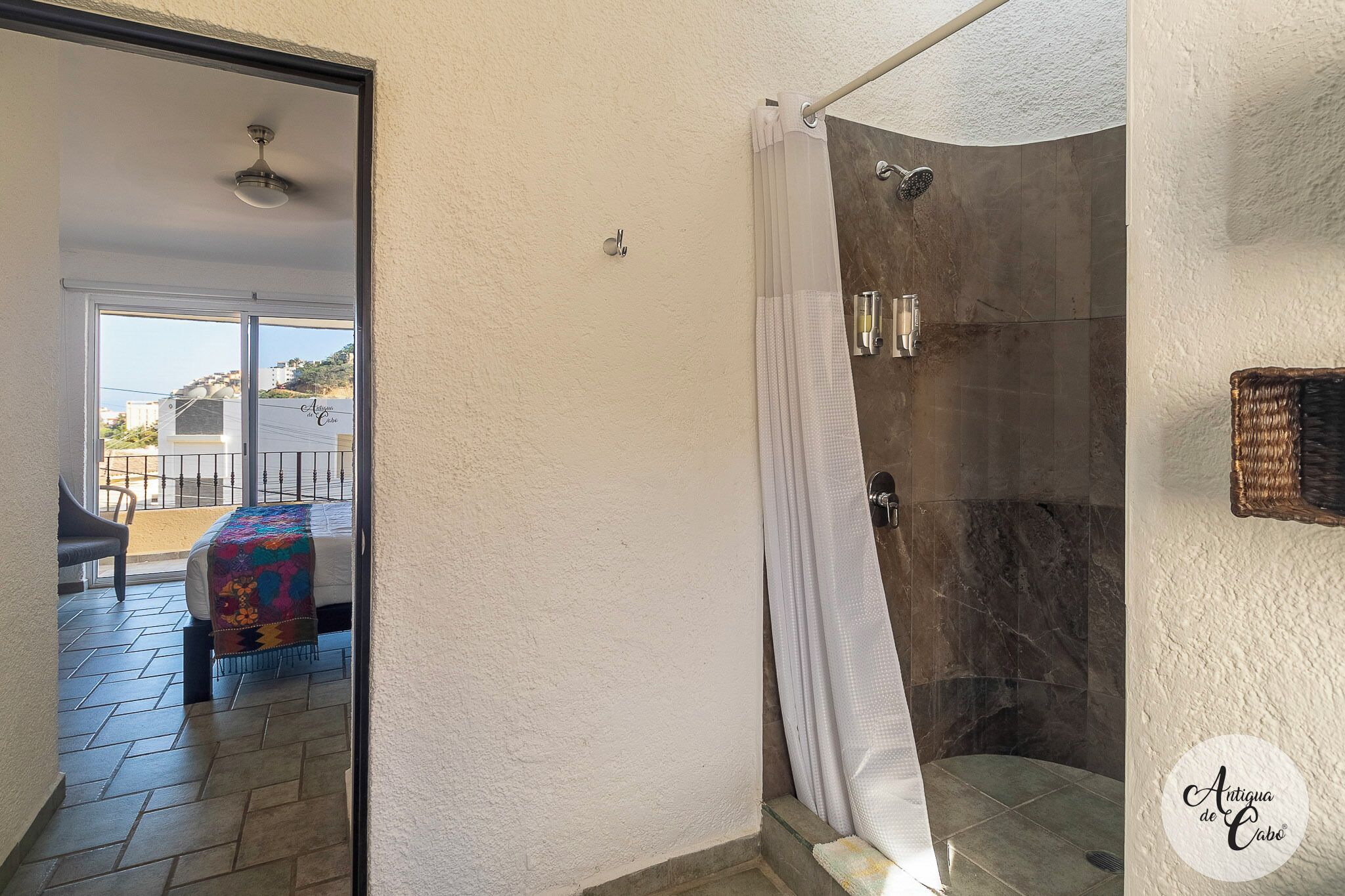Un baño con ducha, toallero y vistas al balcón exterior.