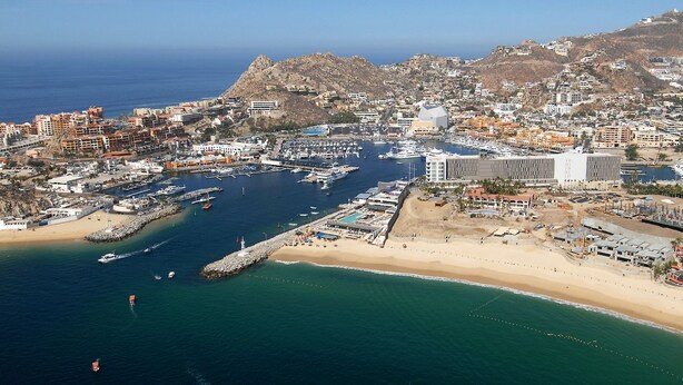 An aerial view of a coastal city with a marina, sandy beaches, and mountainous terrain in the background. - Antigua de Cabo (Cabo San Lucas)