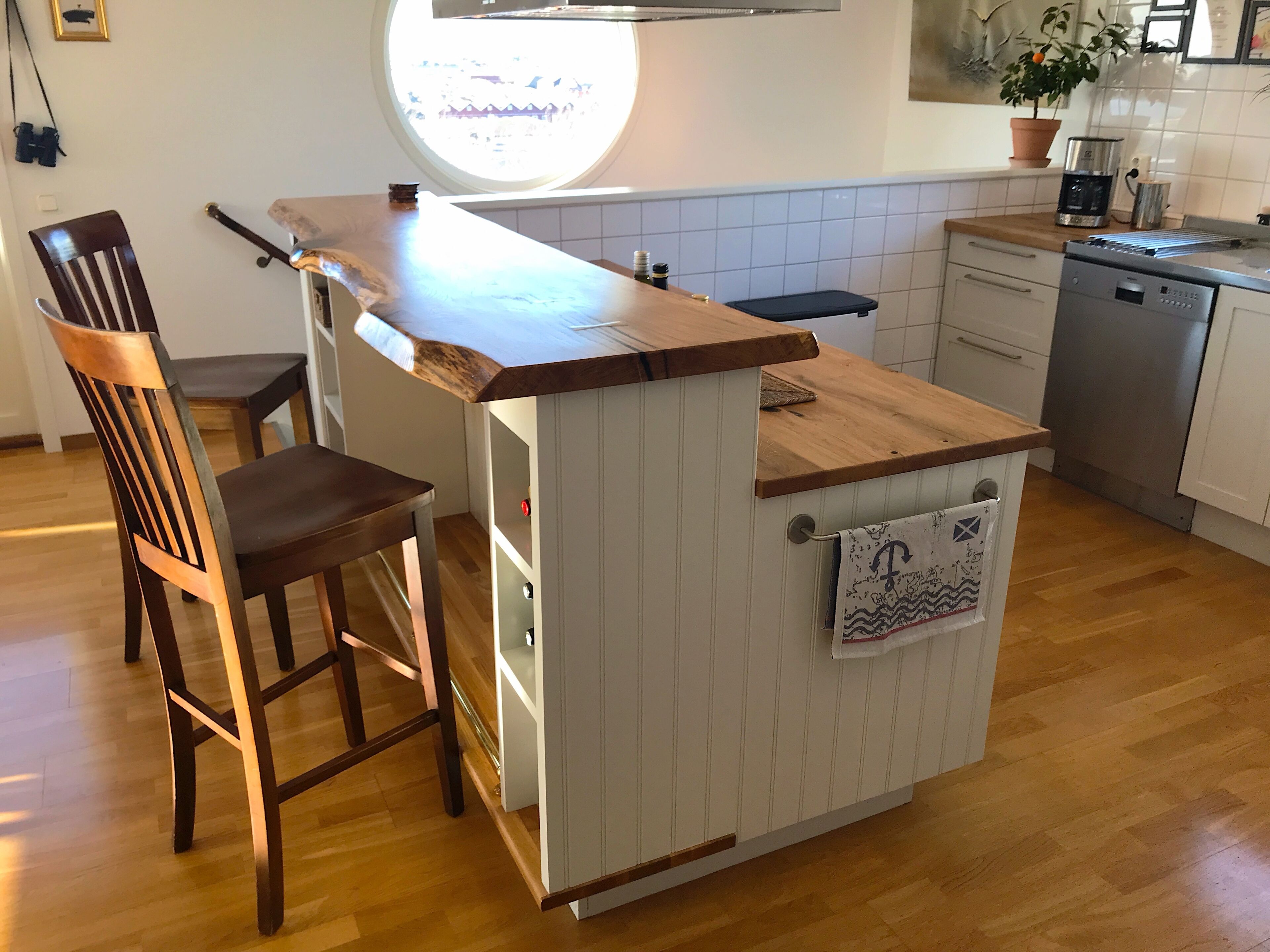 A compact kitchen with a wooden countertop, a built-in sink, and a small island with a towel hanging.