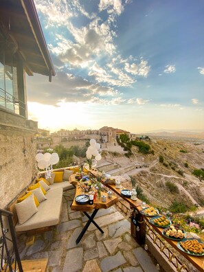 An outdoor dining area with a view of a historic building and landscape. - Zen Cappadocia (Nevsehir)